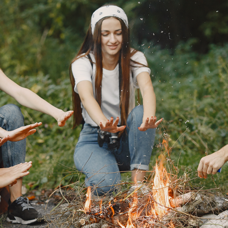 adventure-travel-tourism-hike-people-concept-group-smiling-friends-forest-people-sitting-near-bonfire 1